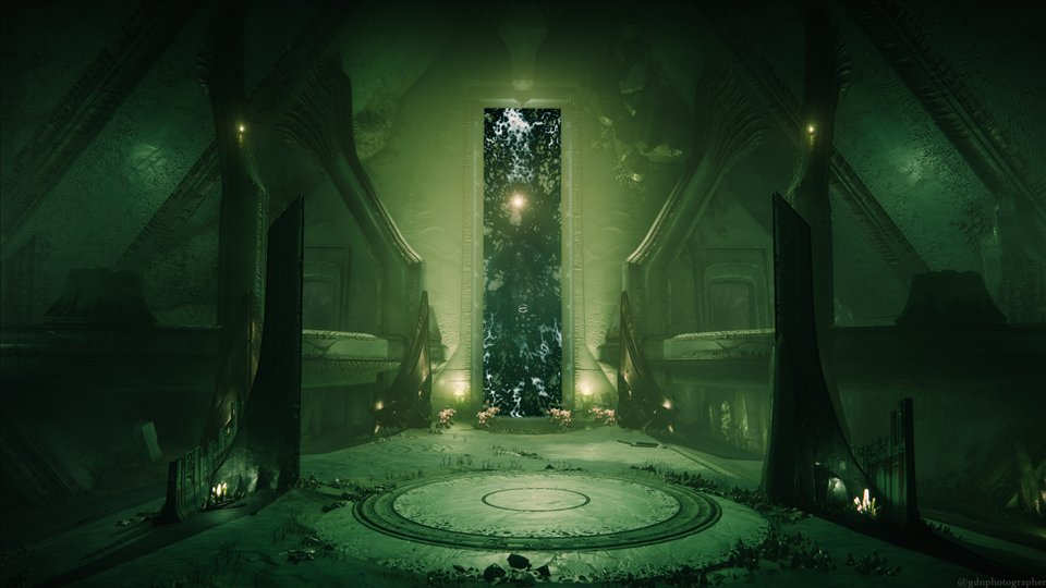 La Basilique : une porte sombre entre deux statues, dans une lumière verte