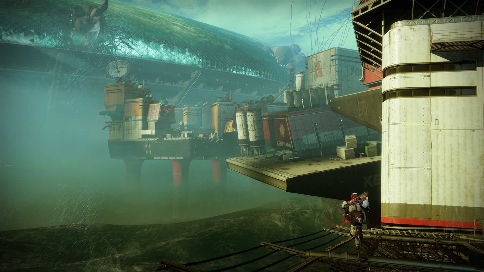 Un Gardien de dos sur une passerelle de Titan, face aux plateformes et à la mer verte
